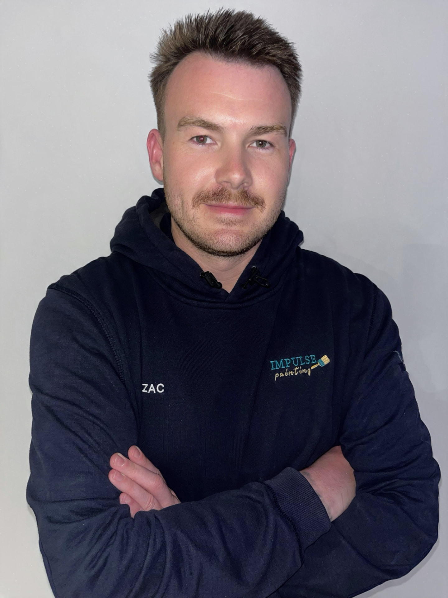 Zac England, owner of Impulse Painting, wearing the company hoodie